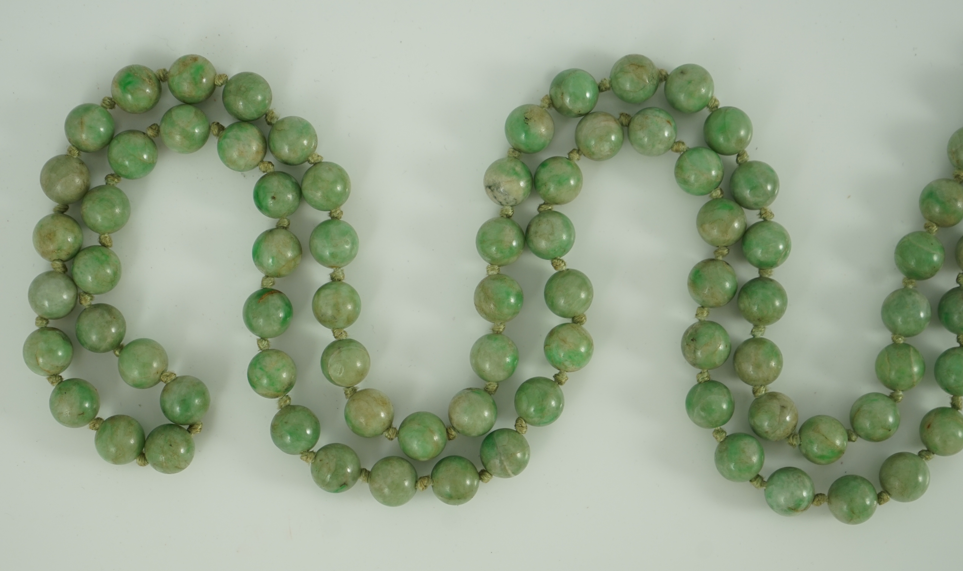A Chinese jadeite pendant and jadeite beads, 19th century, Pendant 3.9 cm, total drop 68 cm